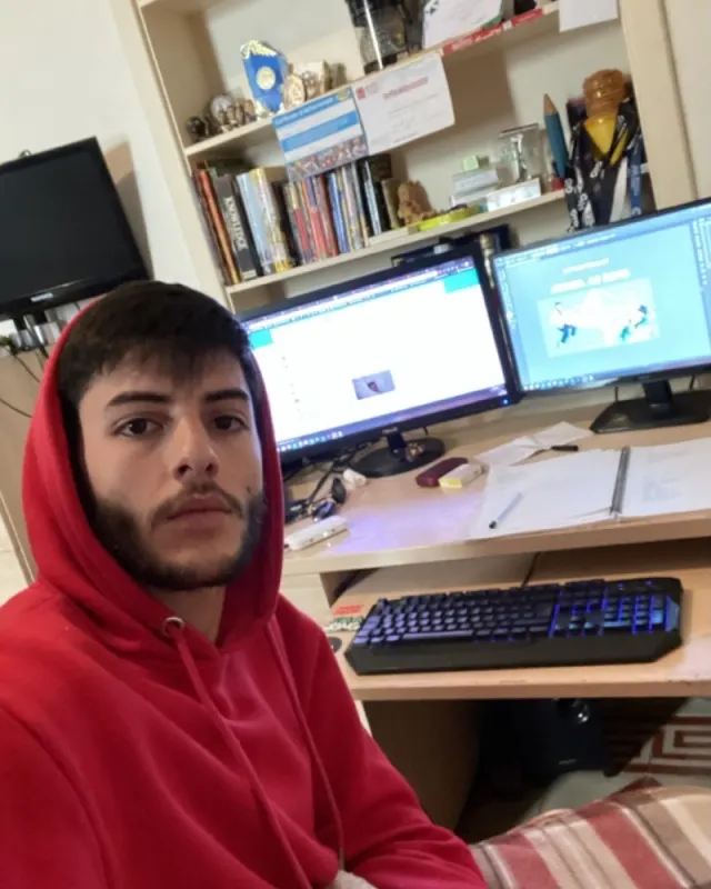 Stephen in a red hoodie at a home desk with two monitors, March 2020